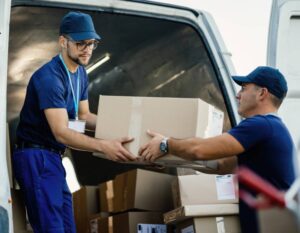 two men moving cardboard box